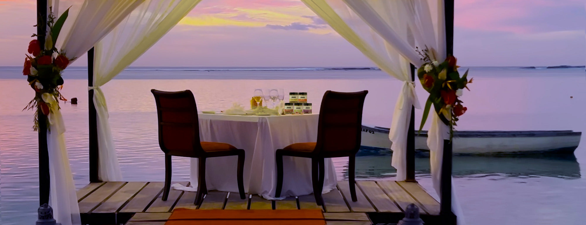 A romantic dinner set on a dock next to a lagoon with a selection of Salted Perfection salts on the table